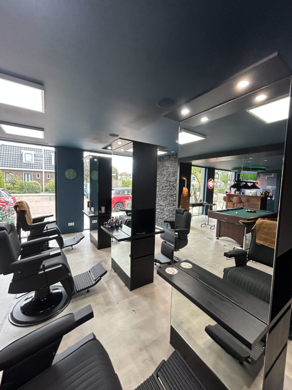 Klanten spelen een potje pool in de barbershop